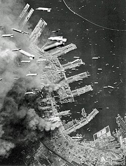 Aerial view of a city under heavy bombing during World War II, illustrating the destructive impact of air raids similar to those depicted in Grave of the Fireflies.